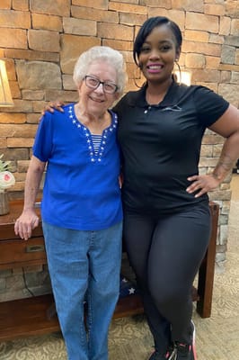 Resident and staff member smiling together