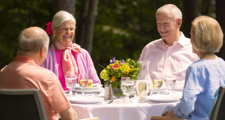 Residents enjoying a meal outdoors at a table setting
