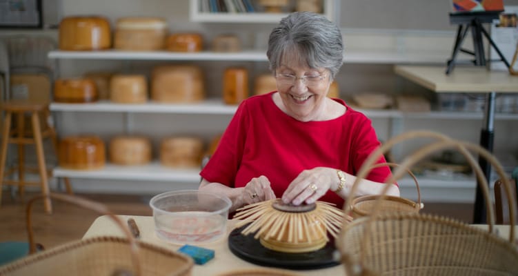 Senior woman enjoying basket weaving activity
