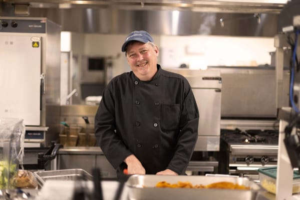 Chef smiling in a kitchen preparing food