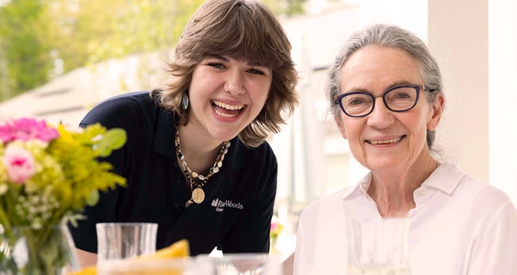 A caregiver and resident smiling together outdoors