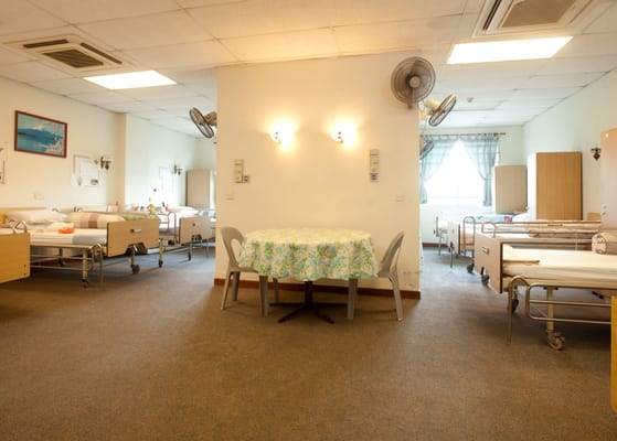 Interior view of a shared room with beds and a table