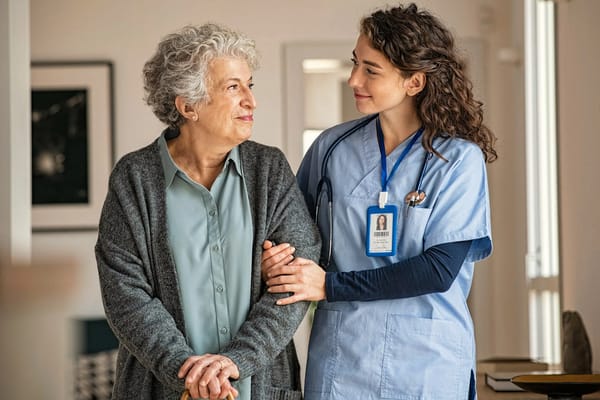 Staff member assisting a resident in a hallway