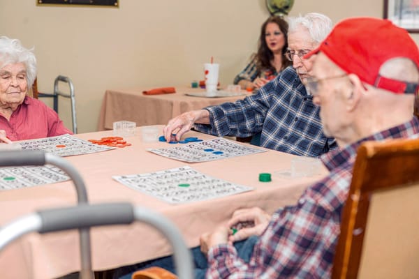 Residents playing bingo in a facility activity room