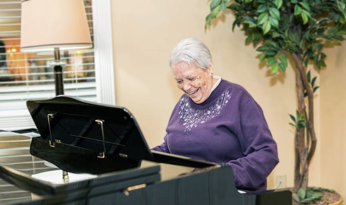 Resident enjoying a piano performance in a common area