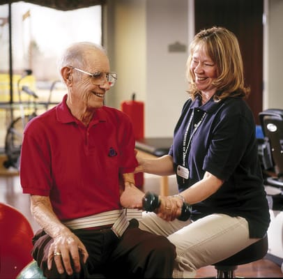 Therapist assisting a resident with weight training