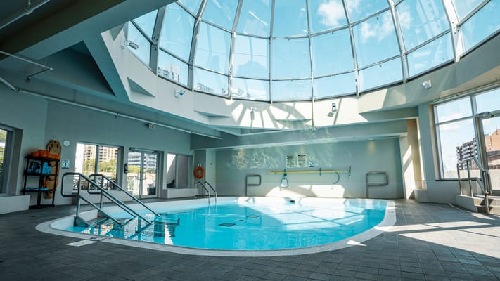 Indoor swimming pool area with skylight ceiling