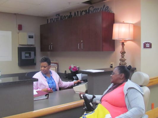 Staff assisting a resident at the reception desk