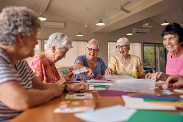 Residents engaged in a crafting activity around a table