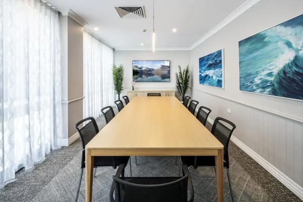 Bright common area with a long table and artwork