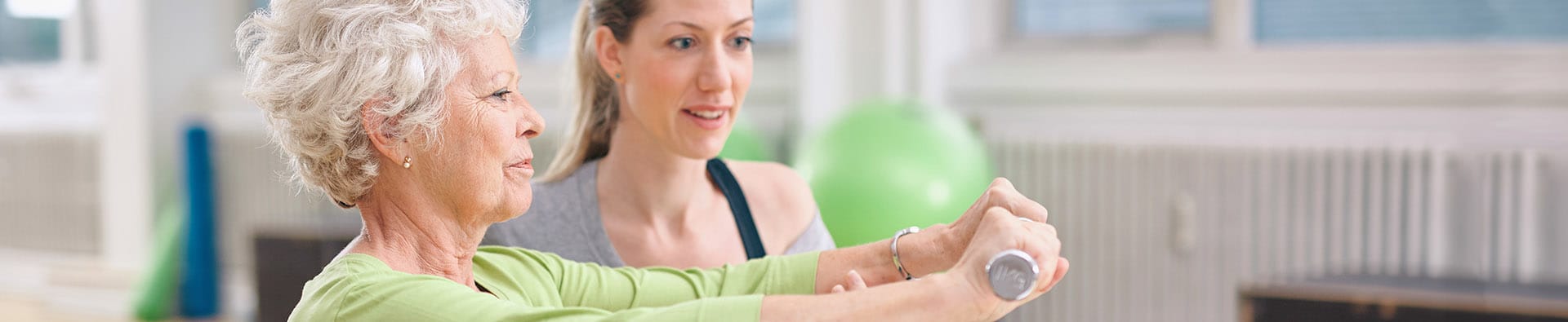 Staff assisting a resident with light exercise