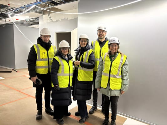 Group of staff and residents in hard hats at the facility