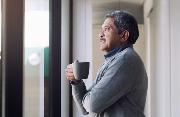 A senior man enjoying a beverage indoors