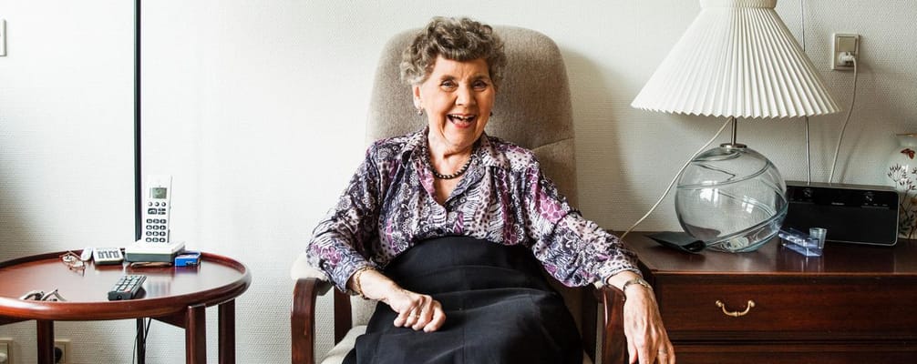 Smiling resident seated in a cozy room