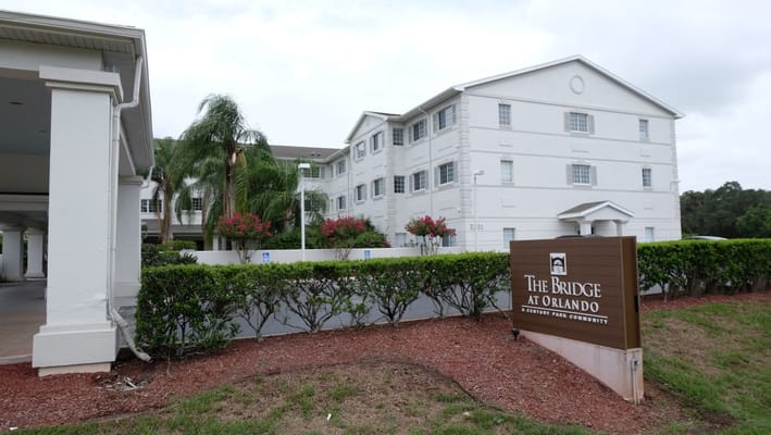 Exterior view of The Bridge at Orlando care facility with signage