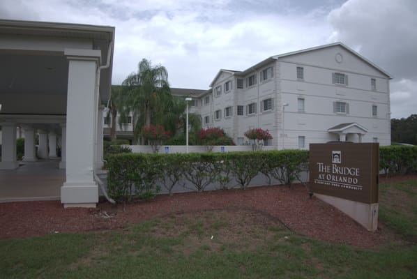 Exterior view of The Bridge at Orlando with sign and building.