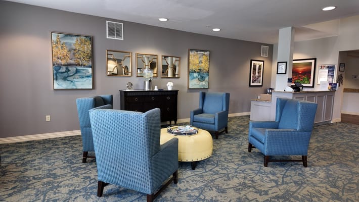 Comfortable blue chairs in a welcoming lobby with artwork