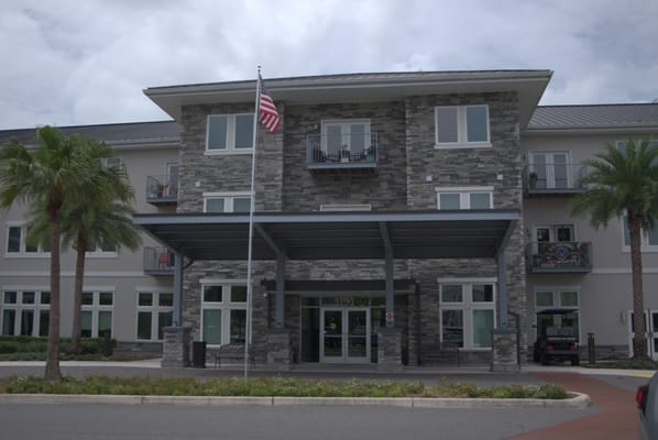 Main entrance of The Landings at Gentry Park with palm trees and an American flag.