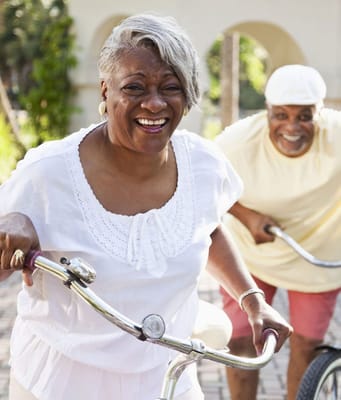 Two seniors enjoying a bike ride outside