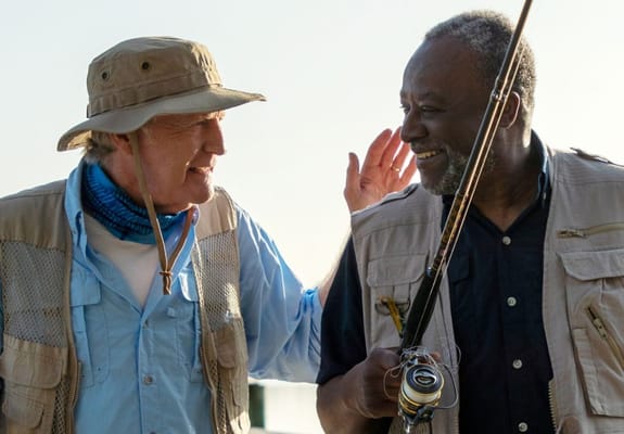Two men enjoying fishing outdoors by the water