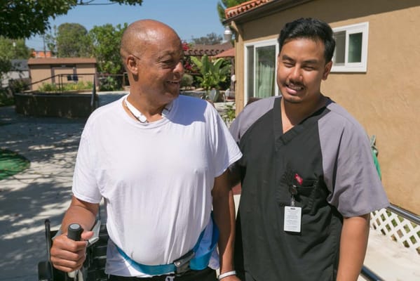 A resident and staff member interacting outdoors