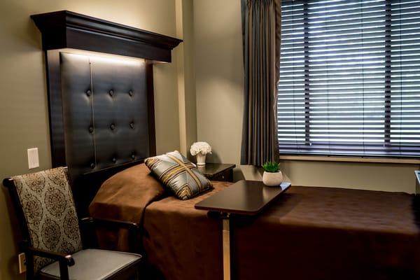 Cozy room setup with a bed and chair in soft lighting