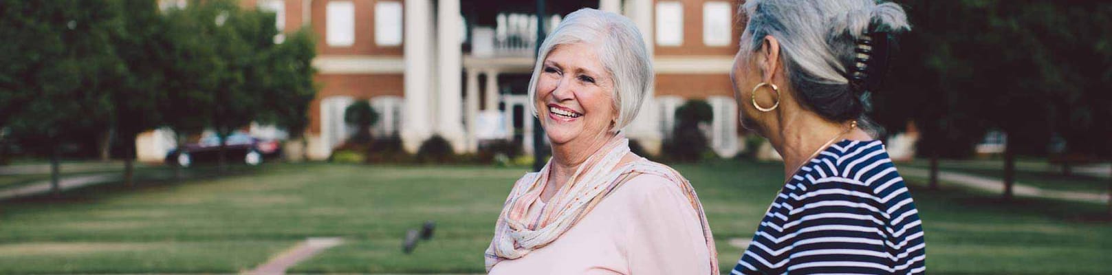Two smiling seniors in a garden area
