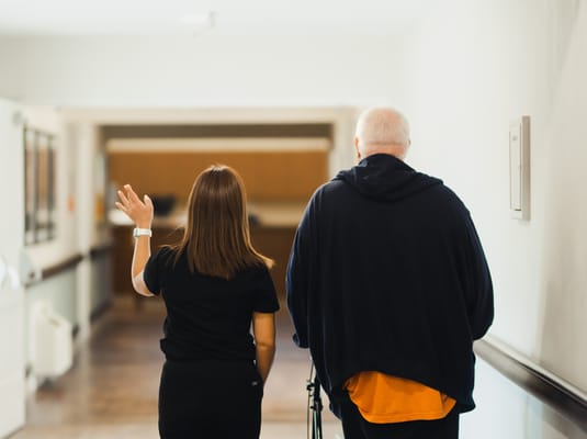Staff member assisting a resident in a hallway