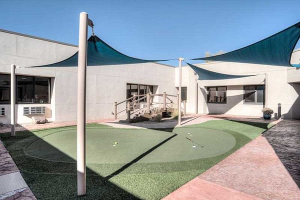 Sunlit outdoor space with landscaping and shade structures