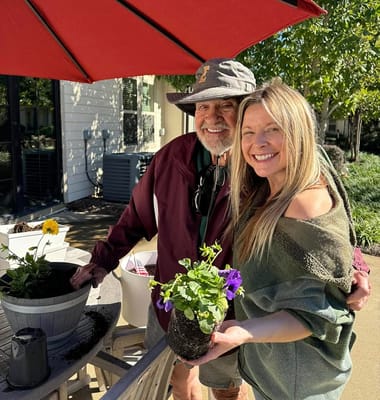 Resident and staff member gardening together outside