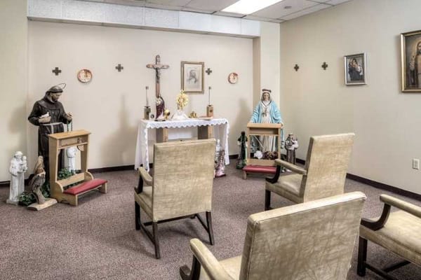 A serene prayer room with chairs and religious figures
