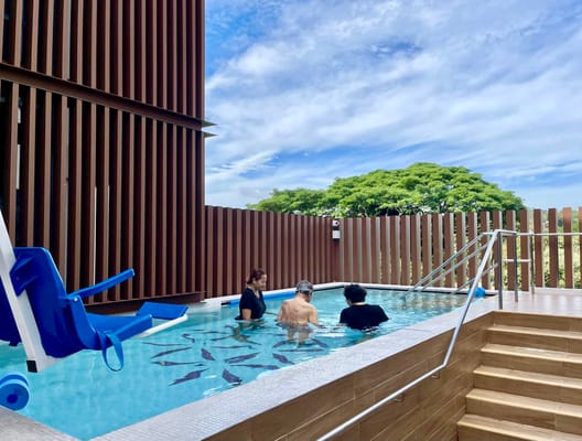 Residents enjoying the pool area with staff supervision