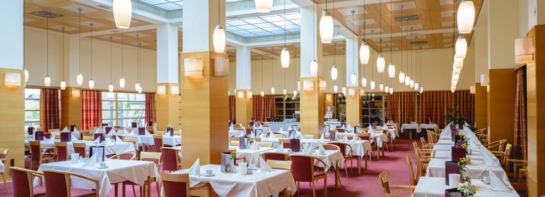 Bright, spacious dining room with tables set for meals