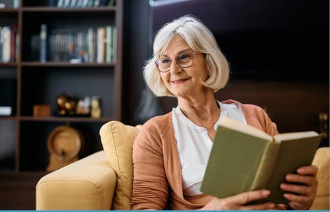 Senior woman reading a book in a cozy chair