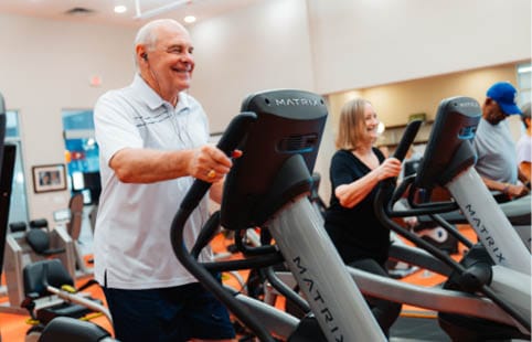 Residents exercising on treadmills in a fitness room
