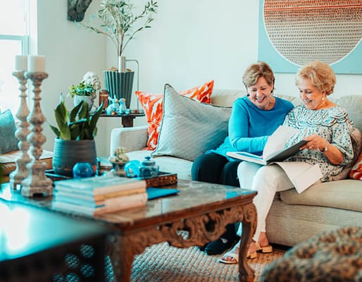 Two residents looking at a photo album in a cozy living room