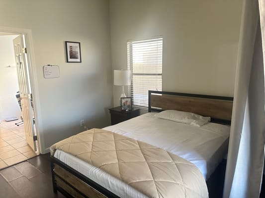 Bright bedroom with a bed, lamp, and window.