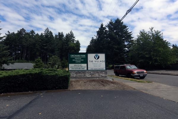 Sign displaying The Village Senior Living at Orchard Park.