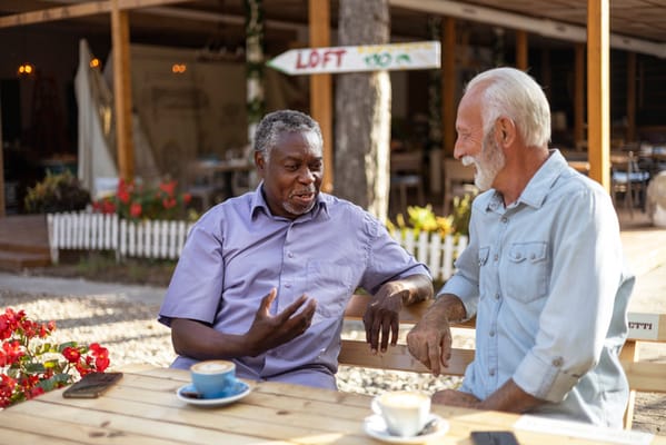 Two men engaged in conversation at an outdoor patio