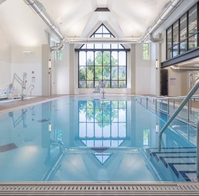 Indoor swimming pool with large windows and reflection