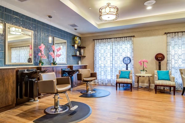 Hair salon area with styling chairs and decorative flowers