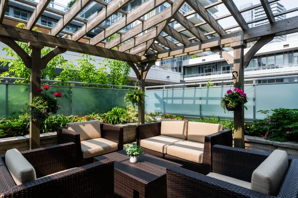 Outdoor seating area with pergola and flower beds