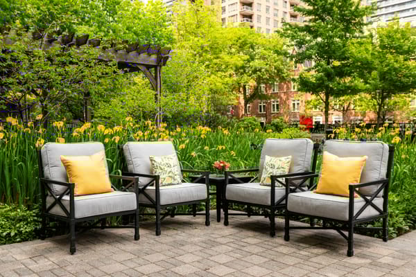 Outdoor seating area surrounded by greenery and flowers