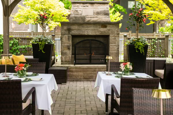 Outdoor dining area with tables and greenery