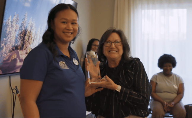 Two staff members celebrating with an award