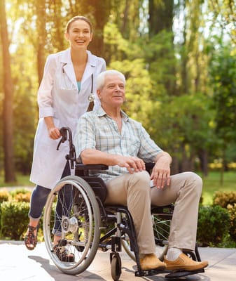 A healthcare worker assisting a resident in a garden.