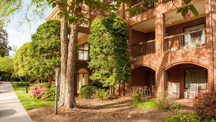 Exterior view of a senior living building with gardens