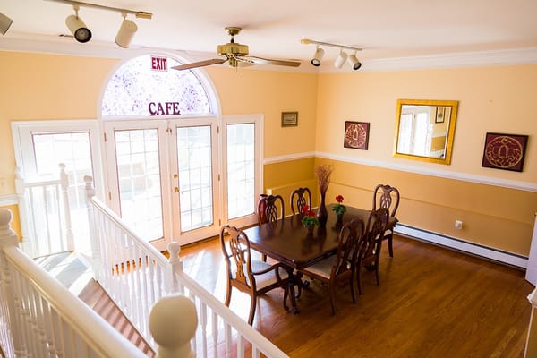 Dining area with a large table and exit to a café