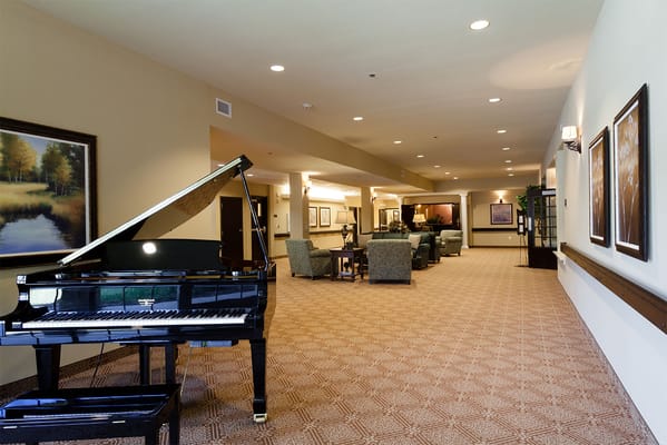 Interior view of a common area with a piano and seating