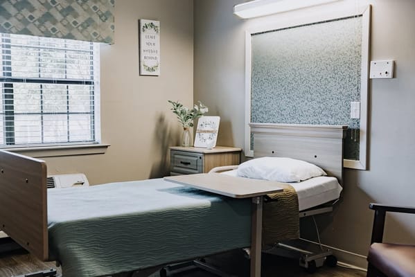 A comfortable resident room with a hospital bed and decor